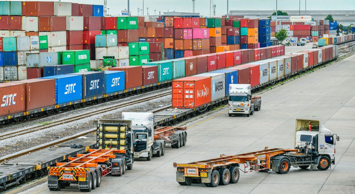 Vrachtwagens naast een spoorlijn op het terrein van een containerhaven